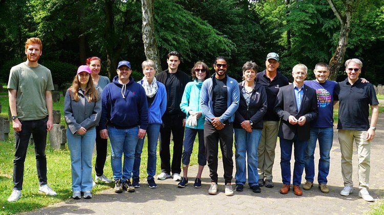 Teilnehmende am Kriegsgräber-Pflegeeinsatz lassen sich gemeinsam mit Mitgliedern des Landesvorstandes fotografieren.